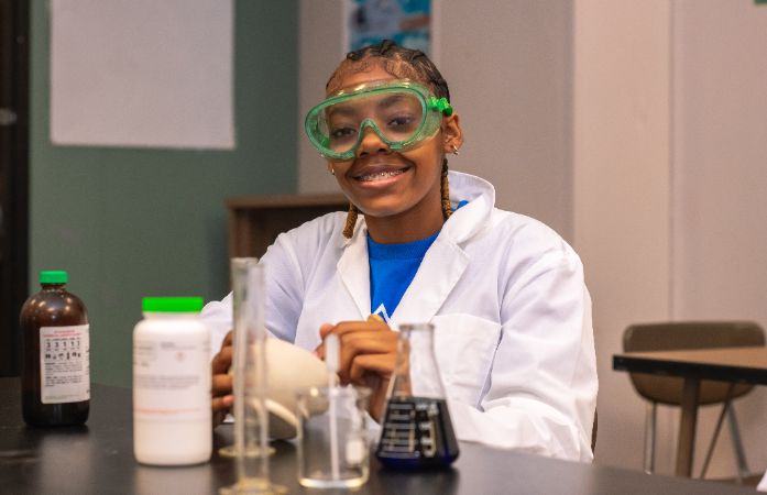  High School student working with beakers in science lab